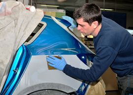 workman repairing wheel arch of car body